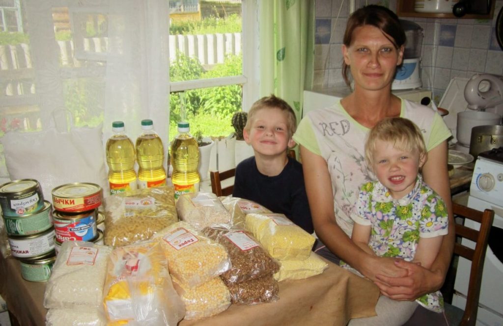 Человек помогает другому подняться, символизируя систему льгот и поддержки